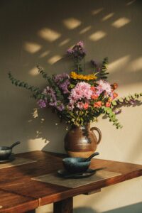 jug of flowers on a wood table rustic setting