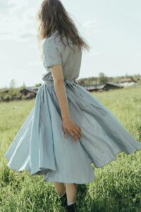 girl walking in field with blue dress